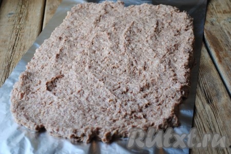 В мясной фарш добавить одно сырое яйцо, пропущенный через мясорубку лук, соль, чёрный молотый перец и панировочные сухари. Всё хорошо перемешать, фарш отбить. Готовый фарш разложить на фольге в форме прямоугольника (как на фото).