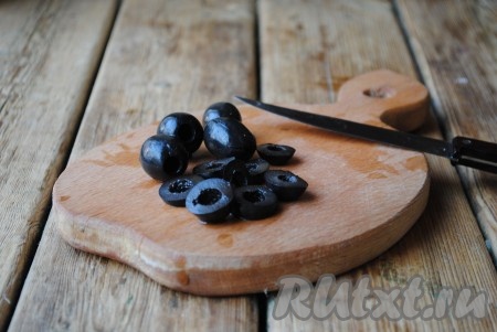 Оливки нарезать кольцами.&nbsp;
