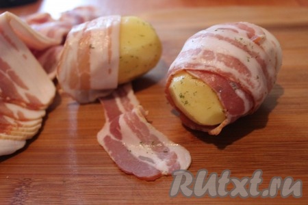 Каждый клубень картофеля обернуть полоской бекона.
