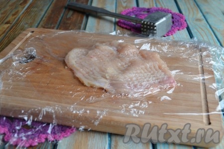 Каждый кусочек накрыть пищевой пленкой и легко отбить молотком. 