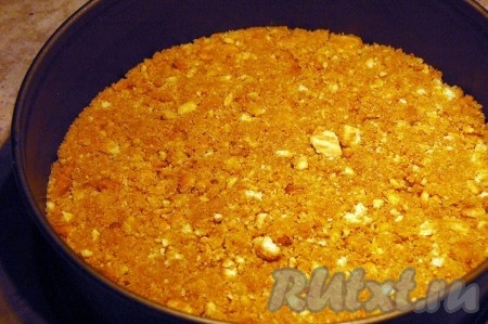 Растопленное сливочное масло соединить с крошками печенья, размешать и разместить в разъемной форме, хорошо утрамбовать.