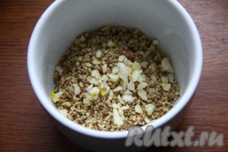 В первую очередь приготовим ореховую заправку для салата. Орехи измельчить в блендере в крошку. Чеснок мелко порубить ножом (выдавливать чеснок не рекомендуется) и добавить к орехам.