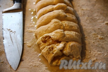 Подворачиваем края теста внахлест друг на друга. Ножом разрезаем получившийся рулет на порционные кусочки.
