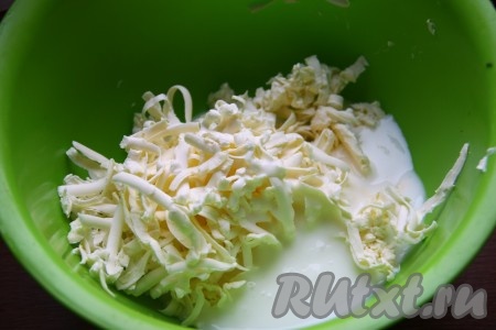 Для приготовления теста сливочное масло натрем на крупной терке и смешаем со сметаной.