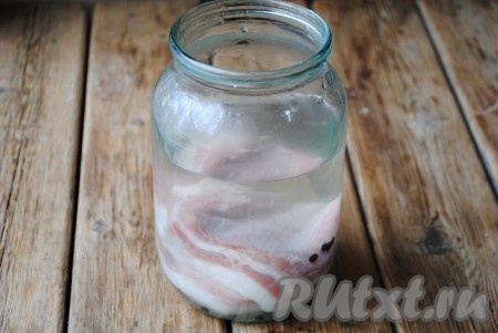 Чеснок очистить и пропустить через пресс. Чесночную кашицу смешать с 2-3 столовыми ложками соли и обвалять сало со всех сторон. Выложить сало в банку и залить маринадом. Накрыть банку крышкой и оставить сало просаливаться при комнатной температуре на 2 дня.
