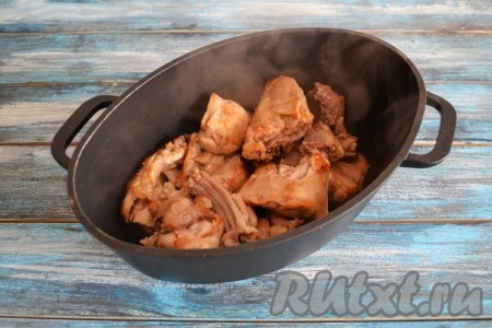 Переложить обжаренные кусочки кролика в казан или толстостенную кастрюлю.
