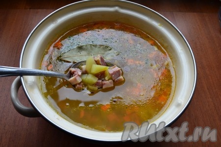 Когда картофель будет готов, выложить в кастрюлю содержимое сковороды, перемешать. Также добавить в суп специи, лавровый лист и измельченный чеснок.