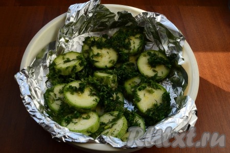 Чашу для варки на пару застелить фольгой и выложить кабачки с зеленью.