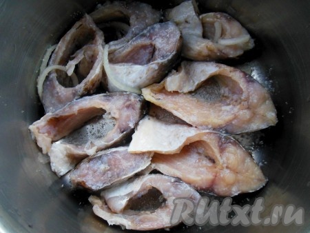 На дно эмалированной кастрюли (или кастрюли из нержавеющей стали) насыпьте щепотку соли, часть специй, свежего и маринованного лука, затем выложите кусочки карасей.