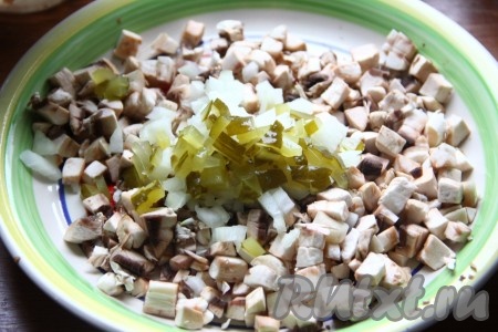 Добавить к грибам мелко нарезанную луковицу, мелко нарезанные огурцы и выдавленный чеснок.
