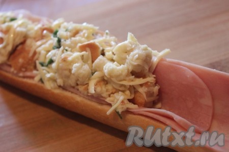 В "лодочки" из багета аккуратно выложить ломтики ветчины и пропитавшуюся начинку (если нужно, слегка отожмите её).
