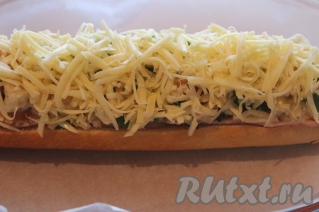 Для получения красивой корочки сверху фаршированный багет посыпать сыром и выложить на противень, застеленный пекарской бумагой. Выпекать в заранее разогретой до 180-200 градусов духовке, примерно, 15-20 минут (до появления золотистой корочки).