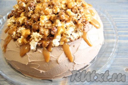 Готовый торт с кремом из творожного сыра украсить по желанию. Я украсила шоколадным попкорном и полила карамелью. Для приготовления карамели соединить 3 столовые ложки сахара, 1 столовую ложку мёда и 1 чайную ложку сливочного масла, поставить на огонь и варить до однородности на небольшом огне, помешивая, в течение 5-7 минут. Пока карамель горячая, полить торт и посыпать попокорном.
