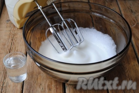 Во взбитые белки влить воду комнатной температуры и аккуратно перемешать ложкой или лопаткой, стараясь не осадить белковую массу. 