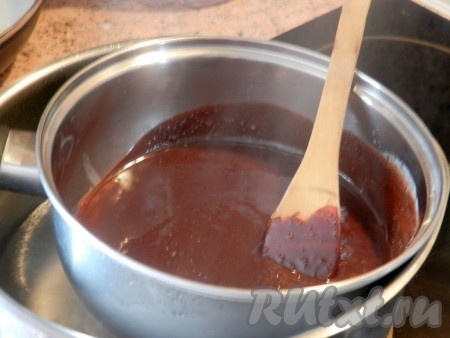 Взять кастрюлю, объём которой будет больше, чем кастрюля с шоколадом и маслом, влить в неё воду, поставить на огонь, довести воду практически до кипения, уменьшить огонь до среднего. Поверх кастрюли с водой поставить кастрюльку с маслом и шоколадом. Дно кастрюльки с шоколадом и маслом должно быть в воде, но при этом дно не должно касаться дна кастрюли с водой. На получившейся водяной бане растопить шоколад и сливочное масло, непрерывно перемешивая. Затем в шоколадно-масляную смесь добавить 100 грамм сахара и, продолжая перемешивать, прогреть до полного растворения сахара. Снять шоколадно-масляную смесь с огня и остудить.