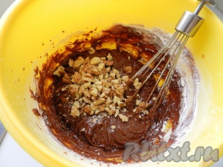 В миску с яйцами, взбитыми с солью, добавить остывшую шоколадно-масляную смесь и муку, перемешать венчиком (или столовой ложкой). Консистенция шоколадного теста для брауни должна напоминать густую сметану. Затем всыпать крупно порубленные орехи, вмешать их в тесто.&nbsp;