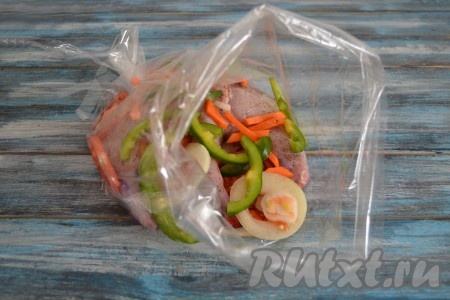 Выложить нарезанные овощи к мясу в рукав.
