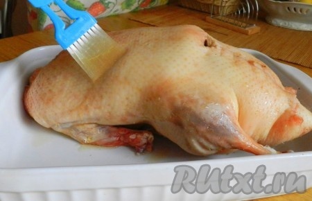 Поверхность утки с помощью кисточки смочить смесью коньяка и сока. Поставить в разогретую до 200 градусов духовку.
