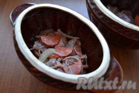 Затем в горшочек выложить половину мяса кролика с луком и морковью.
