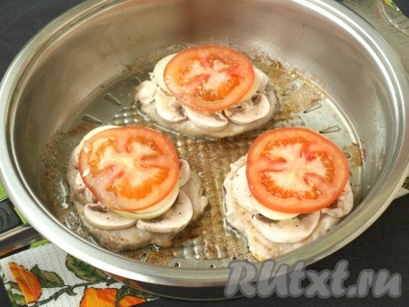 Капнуть на грибы немного сметаны (для скрепления конструкции), выложить по колечку лука. Затем на лук также капнуть сметану и выложить кружочки помидоров.
