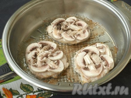 Мясо перевернуть и на обжаренную сторону нанести немного сметаны, сверху выложить пластинки шампиньонов, посолить и поперчить грибы.

