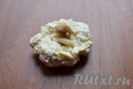 Влажными руками сформировать небольшие шарики, внутрь вложить по 1-2 арахиса.
