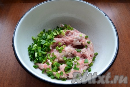 Пока тесто поднимается, займёмся начинкой для беляшей. Зелёный лук нужно промыть водой, обсушить, мелко нарезать. Можно готовить и с репчатым луком, его нужно будет очистить, а затем пропустить через мясорубку (или натереть на крупной тёрке). Фарш можно приготовить в домашних условиях, пропустив кусочки мяса через мясорубку, но можно использовать и покупной фарш. Куриный фарш выложить в миску, добавить измельчённый лук.