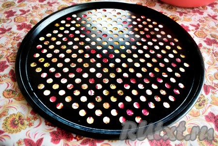 Поднявшееся дрожжевое тесто слегка вымешиваем и делим на 2 равные части (из этого количества теста получается 2 больших домашних пиццы). Начинаем готовить пиццу. Форму для пиццы смазываем растительным маслом, выкладываем одну часть теста на дно формы.