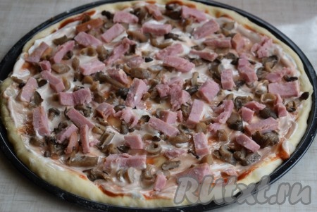 На тесто с грибами выкладываем половину нарезанной ветчины. Сверху обычно я кладу 1-2 помидора, нарезанных на тонкие кружочки (в этот раз помидоры не добавляла).