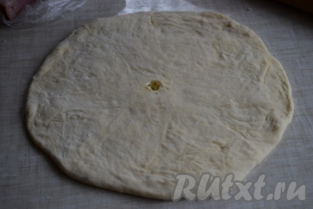 Лепёшку аккуратно, чтобы не порвать, растянуть вначале руками, а затем раскатать с помощью скалки. Толщина хачапури должна быть не более 10 мм. Переложить хачапури на противень, застеленный пергаментом или смазанный маслом. В центре лепёшки сделать пальцем дырочку для выхода пара.
