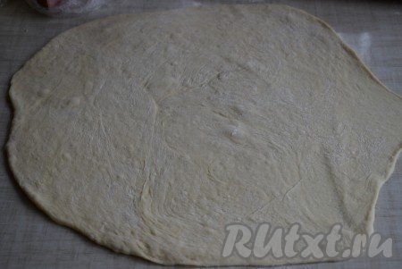 На столе, присыпанном мукой, раскатать достаточно тонко вначале одну часть теста в круг.