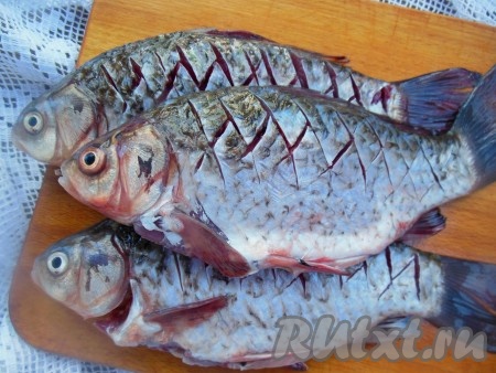 Хорошо промойте под проточной водой, удалите черную пленочку внутри. На поверхности каждого карася с двух сторон сделайте не очень глубокие насечки от спинки к брюшку "крест-накрест", это делается для того, чтобы мелкие косточки не чувствовались в готовой рыбке.