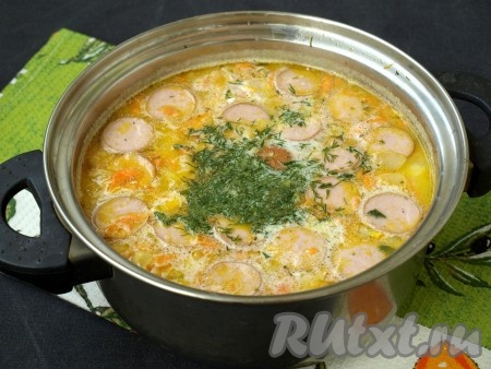 Затем в кастрюлю добавить сосиски, обжаренные с луком и морковью, укроп, соль и перец по вкусу. Варить суп 2 минуты.
