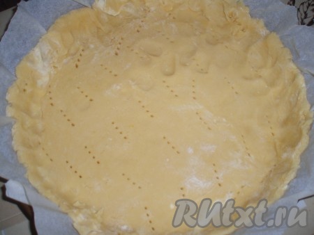 Охлажденное тесто раскатать по размеру формы для выпечки, выложить в форму, сформировать бортики из теста. Тесто наколоть вилкой. Дно формы для выпечки желательно выложить пергаментом (если форма не силиконовая). Подготовленную основу из песочного теста запечь в разогретой духовке в течение 10-12 минут при температуре&nbsp;180 градусов.
