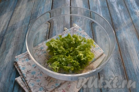 Листья салата вымыть холодной водой, обсушить и нарвать руками на небольшие кусочки, выложить в миску.