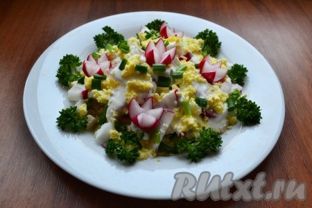 Сверху салат полить сметаной и посыпать раскрошенными желтками. По краю украсить петрушкой или любой другой зеленью.