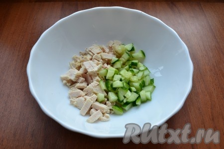 Куриную грудку отварить заранее в течение 25-30 минут после закипания воды, в процессе варки воду подсолить. Затем варёное мясо полностью остудить. Сварить вкрутую яйца (в течение минут 9-10 после закипания воды), затем остудить их и очистить. Огурчик и редис вымыть, обрезая кончики с двух сторон. Варёное куриное мясо и свежий огурец нарезать кубиками, выложить в миску.