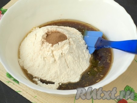 К жидким ингредиентам просеять муку с разрыхлителем, добавить по щепотке соли и кардамона, а также корицу.
