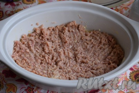 Поверх слоя картофеля равномерно распределить рыбные консервы.