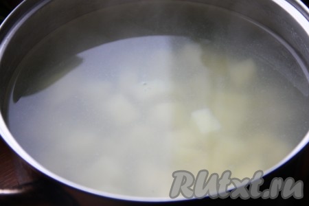 Картофель очистить, нарезать кубиками и залить бульоном или водой, поставить на огонь, после закипания уменьшить огонь и варить картошку до готовности.