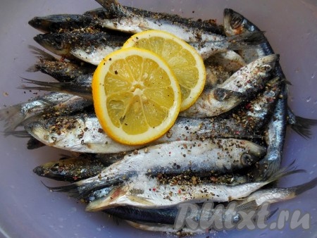 Добавьте к салаке соль по вкусу, колечки лимона и измельченную смесь перцев, хорошо перемешайте и оставьте мариноваться на 15-20 минут в холодильнике.