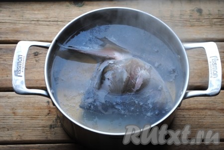 Голову и хвост рыбы хорошо промыть под проточной водой, из головы удалить жабры и глаза. Воду довести до кипения, опустить голову и хвост рыбы. Продолжить нагревать воду на сильном огне, пока она снова не закипит, затем уменьшить огонь, убрать образовавшуюся пену и варить рыбный бульон 30 минут. 