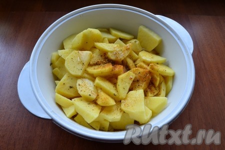 Картошку очистить, нарезать средними кусочками, поместить её в огнеупорную кастрюльку пригодную для приготовления в микроволновой печи. Посолить, посыпать специями для картофеля, влить растительное масло. Картофель перемешать.