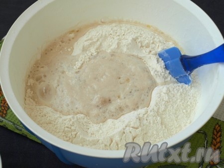 В глубокую миску просеять всю муку, влить опару (не дожидаясь пока она поднимется) и тут же хорошо размешать. Вскипятить оставшуюся воду, влить её в тесто и перемешивать тесто лопаткой, пока оно немного не остынет, затем продолжить замес руками.
