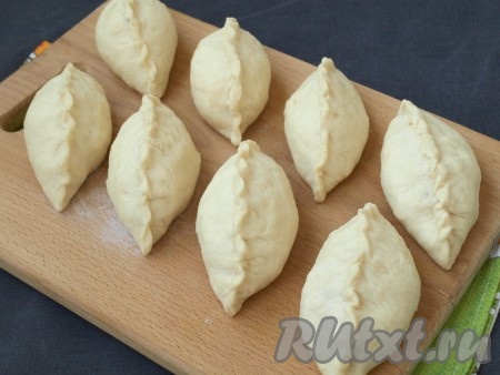 Раскатываем каждый кусочек постного теста в лепёшку, выкладываем по 2 столовые ложки капусты и хорошо защипываем тесто сверху. Затем также лепим пирожки из второй части теста.
