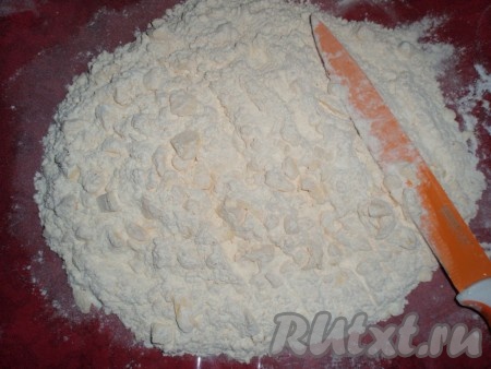 Холодное сливочное масло нарезать на небольшие кусочки, добавить к смеси муки и сахарной пудры, порубить ножом (или растереть руками) до образования мелкой крошки.