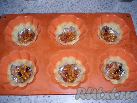 Духовку нагреть до температуры 200 градусов.&nbsp;Подготовленные формы поставить в нагретую духовку и выпекать корзиночки до лёгкого подрумянивания (около 15 минут, продолжительность выпечки во многом зависит от свойств духовки). Пекутся они довольно быстро. Испечённые сладкие корзиночки из песочного теста вынуть из духовки.