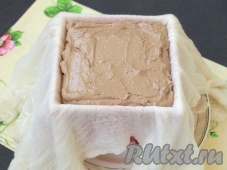 Пасочницу поставить в тарелку, застелить марлей в 2-3 слоя так, чтобы края марли свисали с краёв пасочницы, и выложить творожную массу.
