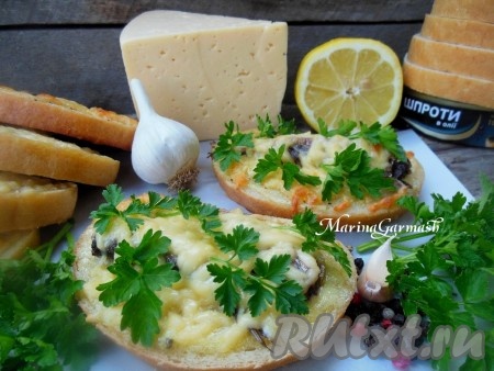 На противень, застеленный пергаментом, выложите бутерброды так, чтобы они не соприкасались друг с другом, и отправьте на 5-7 минут в духовку, разогретую до 180 градусов (можно запечь и в микроволновке на максимальной мощности в течение 2-3 минут). Украсьте горячие бутерброды со шпротами зеленью и подавайте к столу (для себя я перед подачей взбрызгиваю бутерброды соком лимона). Попробуйте, очень вкусно!