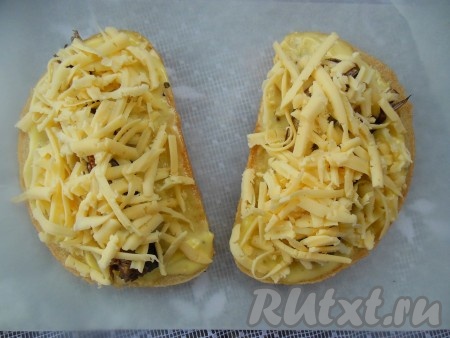 Посыпьте сыром бутерброды со шпротами.
